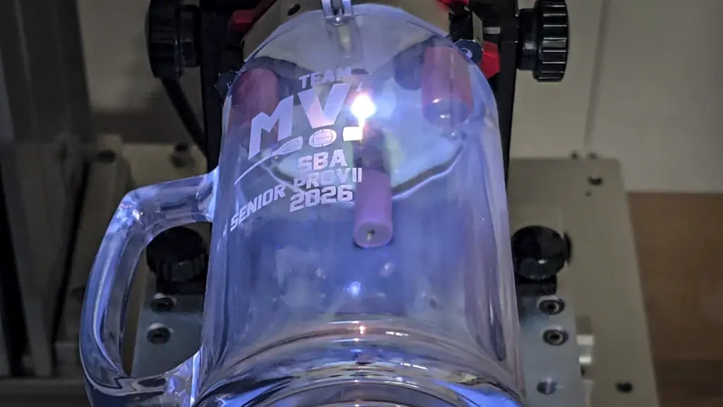 Laser engraving machine engraving a stainless steel tumbler in Saskatoon
